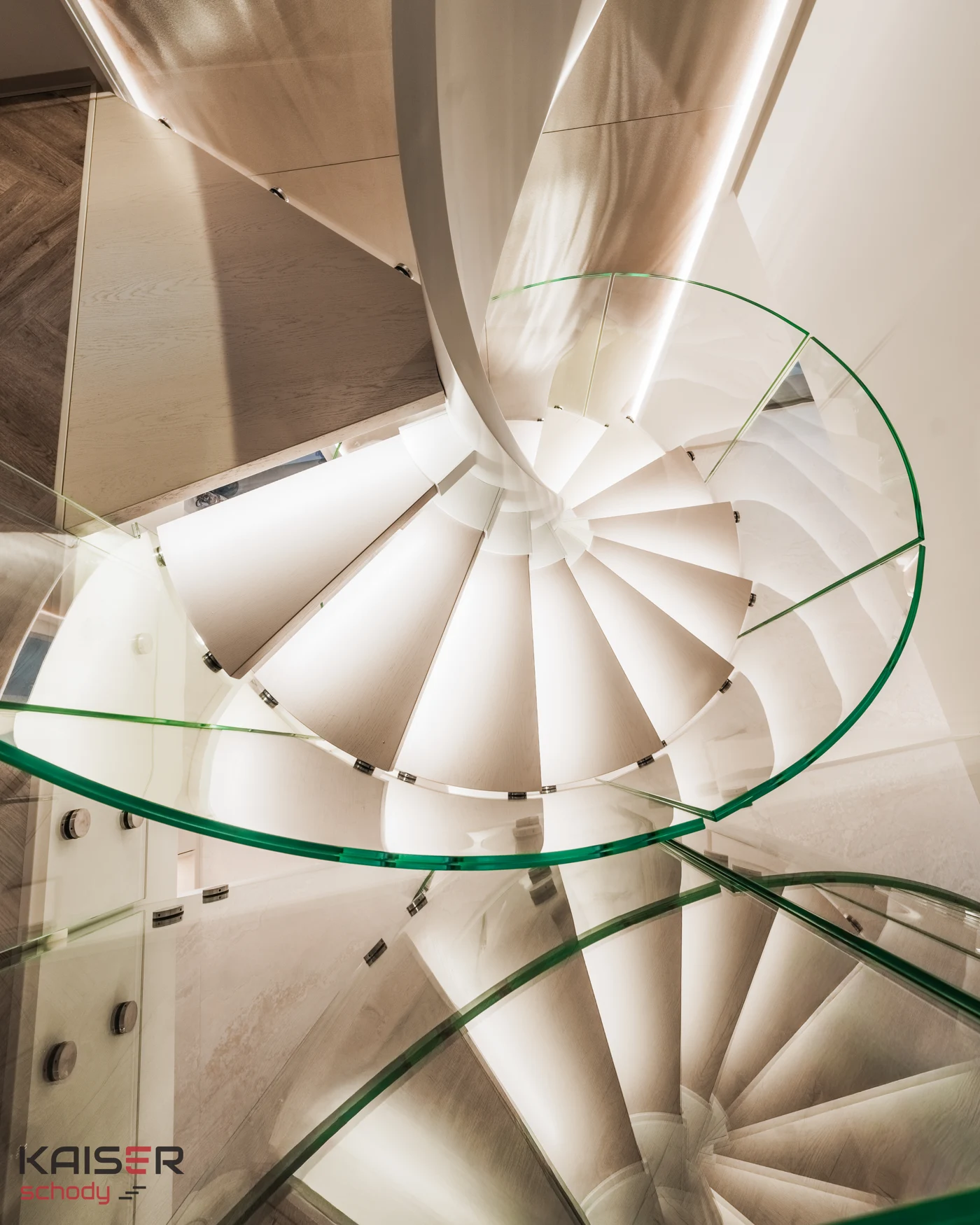 Curved glass around a light-coloured spiral staircase